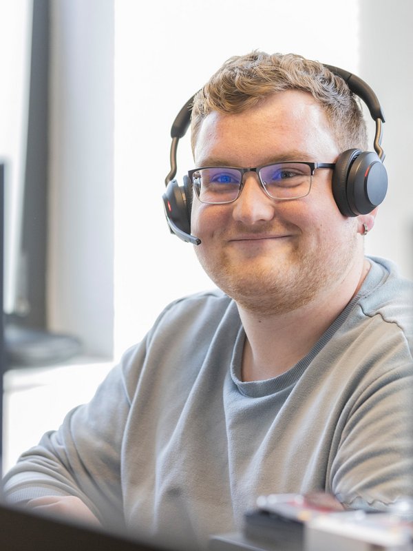 Ein Mann mit Headset arbeitet am Computer